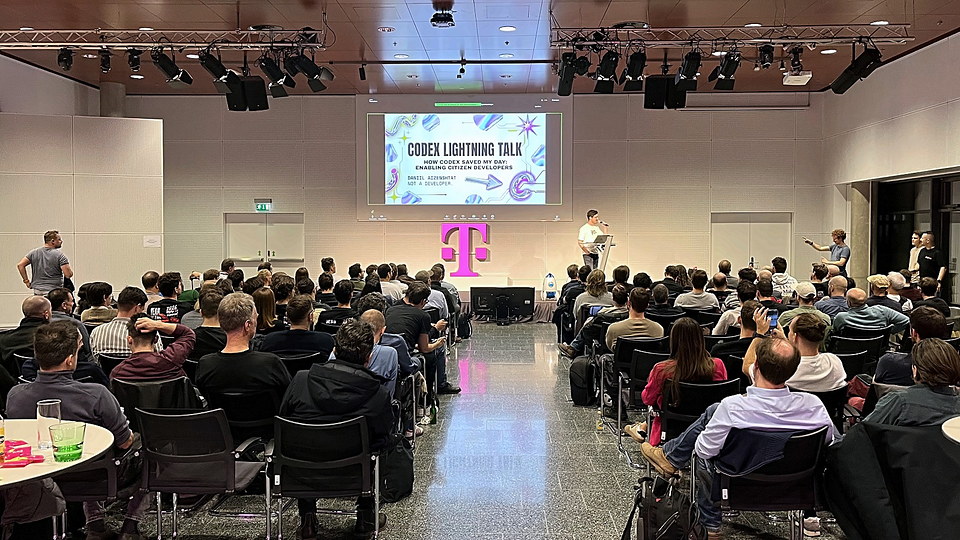 The auditorium at Vienna AI Engineering seen from the back, title slide on screen